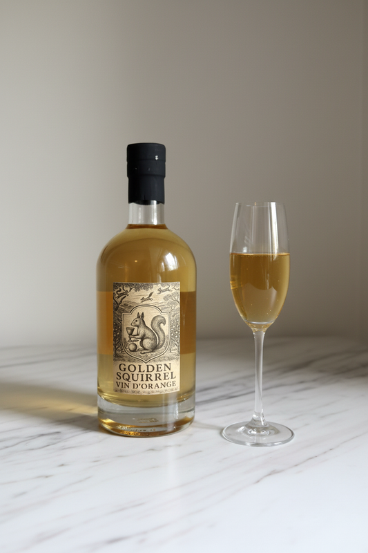 Golden Squirrel Vin d'Orange 750ml bottle on white marble with champagne flute